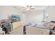 A spacious bedroom has a large TV, neutral carpet and trim and a ceiling fan at 6961 King Creek Dr, Sun City Center, FL 33573