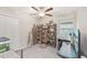 Bedroom with ceiling fan, a large bookshelf, and a desk underneath the window at 6961 King Creek Dr, Sun City Center, FL 33573