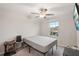 A simple bedroom features a gray bed, a ceiling fan, and natural light from the window at 6961 King Creek Dr, Sun City Center, FL 33573