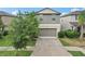 Two-story home featuring a two-car garage, well-maintained lawn and mature tree at 6961 King Creek Dr, Sun City Center, FL 33573