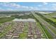 Aerial view of a suburban neighborhood along a highway, featuring serene lakes, lush landscapes, and organized residential blocks at 6961 King Creek Dr, Sun City Center, FL 33573