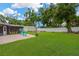 Expansive backyard with a brick patio, lush lawn, white fence, and storage shed, perfect for outdoor living at 704 Childers Loop, Brandon, FL 33511