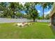 Expansive backyard featuring a well-maintained lawn, lush trees, and a white fence for privacy and security at 704 Childers Loop, Brandon, FL 33511