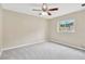 Spacious bedroom with neutral carpet, a ceiling fan, and a window providing natural light at 704 Childers Loop, Brandon, FL 33511