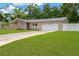 Well-kept single-story home with a spacious driveway, attached garage, and lush green lawn at 704 Childers Loop, Brandon, FL 33511