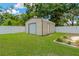 Backyard features a well-maintained storage shed on a manicured lawn, fenced for privacy at 704 Childers Loop, Brandon, FL 33511