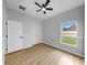 Bedroom with wood floors, a ceiling fan, and a bright window view at 7611 Wood Violet Dr, Gibsonton, FL 33534