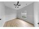 A bright bedroom with wood floors, neutral walls, and a ceiling fan at 7611 Wood Violet Dr, Gibsonton, FL 33534