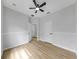 Bright bedroom featuring light wood floors, modern ceiling fan, and neutral walls at 7611 Wood Violet Dr, Gibsonton, FL 33534
