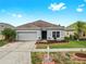 Charming single-story home with a well-maintained lawn, fresh landscaping, and a two-car garage at 7611 Wood Violet Dr, Gibsonton, FL 33534