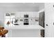 Bright kitchen with white cabinetry, stainless steel appliances, and a large quartz countertop bar at 7611 Wood Violet Dr, Gibsonton, FL 33534