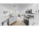 Modern kitchen with white cabinets, stainless appliances, and an open layout to the living area at 7611 Wood Violet Dr, Gibsonton, FL 33534