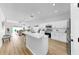 Modern white kitchen featuring a breakfast bar and stainless steel appliances, opening to living space at 7611 Wood Violet Dr, Gibsonton, FL 33534