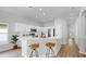 Bright kitchen with white cabinets, stainless appliances and a bar with seating for casual dining at 7611 Wood Violet Dr, Gibsonton, FL 33534