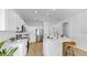 Spacious kitchen featuring white cabinets, stainless steel appliances, bar seating and wood-look flooring at 7611 Wood Violet Dr, Gibsonton, FL 33534
