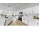 Open kitchen with white cabinets, stainless appliances, wood floors, and view to the living area at 7611 Wood Violet Dr, Gibsonton, FL 33534