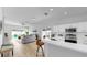 Open-concept kitchen featuring white cabinets, a bar, and stainless steel appliances overlooking the living area at 7611 Wood Violet Dr, Gibsonton, FL 33534