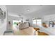 Open-concept living room with wood floors, backyard view, and access to kitchen at 7611 Wood Violet Dr, Gibsonton, FL 33534