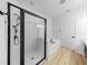 Sleek bathroom featuring modern fixtures, a glass-enclosed shower, a soaking tub, and wood-look flooring at 7611 Wood Violet Dr, Gibsonton, FL 33534