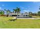 Backyard view of the home with a well maintained lawn, a pool, and patio seating area at 7815 16Th Nw Ave, Bradenton, FL 34209