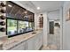 Bar area featuring granite countertops, wine rack, and backyard views with patio seating through a large window at 7815 16Th Nw Ave, Bradenton, FL 34209
