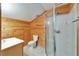 Cozy bathroom features a wood paneled wall, a modern sink, toilet, and glass shower at 7815 16Th Nw Ave, Bradenton, FL 34209