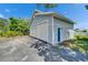 Three car garage with white doors and blue accent door; shaded by lush trees at 7815 16Th Nw Ave, Bradenton, FL 34209