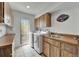 Functional laundry room with wooden cabinets, a utility sink, and modern appliances for efficient chores at 7815 16Th Nw Ave, Bradenton, FL 34209