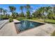 A refreshing dark-bottom swimming pool is surrounded by well-manicured landscaping in this backyard at 7815 16Th Nw Ave, Bradenton, FL 34209