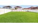 Spacious backyard with lush green lawn and tall white fence at 8111 Brickleton Woods Ave, Gibsonton, FL 33534