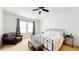 Bright bedroom features a ceiling fan, two windows with patterned curtains, and an upholstered bench at 8111 Brickleton Woods Ave, Gibsonton, FL 33534