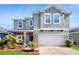 Beautiful two-story home featuring a two-car garage, manicured lawn, and lovely landscaping at 8111 Brickleton Woods Ave, Gibsonton, FL 33534