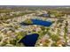 Aerial view of a residential neighborhood featuring the home, a lake, mature trees, and a tranquil setting at 8216 Damara Dr, New Port Richey, FL 34653