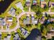 Aerial view of the home with a well-maintained lawn, lush trees, and circular driveway in a serene neighborhood at 8216 Damara Dr, New Port Richey, FL 34653