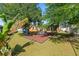 Well-maintained backyard with green grass, mature trees, a seating area and tasteful landscaping at 8216 Damara Dr, New Port Richey, FL 34653