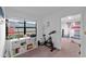 Bright bedroom with a basketball hoop, shelving unit, exercise bike, and view into second room with bunkbeds at 8216 Damara Dr, New Port Richey, FL 34653
