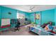 Cozy bedroom featuring cheerful blue walls, white ceiling fan, and an inviting atmosphere at 8216 Damara Dr, New Port Richey, FL 34653