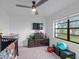 Bedroom with ceiling fan, television, and dark wood dresser adjacent to the window at 8216 Damara Dr, New Port Richey, FL 34653