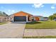 Charming single-story home with a well-maintained lawn, a two-car garage, and bright orange exterior paint at 8216 Damara Dr, New Port Richey, FL 34653