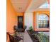 Inviting front porch with decorative plants, chairs, stone accents, and an arched window providing natural light at 8216 Damara Dr, New Port Richey, FL 34653