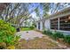 View of a home's backyard with a patio, well-kept lawn, and mature trees at 8619 Gold Pine Dr, Port Richey, FL 34668