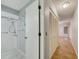 Bathroom with shower stall and tile flooring; hallway view with closet doors at 8619 Gold Pine Dr, Port Richey, FL 34668