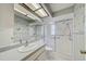 Bright bathroom featuring a shower with sliding doors, neutral colors, and a well-lit vanity at 8619 Gold Pine Dr, Port Richey, FL 34668