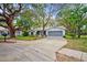 Charming single-story home with a well-manicured lawn, a driveway, and mature trees at 8619 Gold Pine Dr, Port Richey, FL 34668
