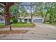 Charming single-story home featuring mature trees, green lawn, and an attached garage at 8619 Gold Pine Dr, Port Richey, FL 34668