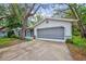 Charming single-story home with well-manicured lawn, mature trees, and a covered front entry at 8619 Gold Pine Dr, Port Richey, FL 34668