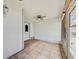 Cozy screened-in porch with tile flooring, ceiling fan, and a view of the front yard at 8619 Gold Pine Dr, Port Richey, FL 34668