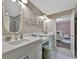 Bright bathroom featuring dual sinks, modern fixtures, decorative mirrors and connecting bedroom access at 9136 Warm Springs Cir, Parrish, FL 34219