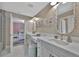 Bright bathroom featuring dual sinks, modern fixtures, decorative mirrors and connecting bedroom access at 9136 Warm Springs Cir, Parrish, FL 34219
