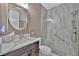 Bathroom features a modern walk-in shower with glass door, pebble floor, and a white marble countertop at 9136 Warm Springs Cir, Parrish, FL 34219